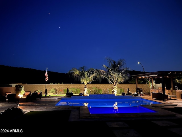 pool at twilight featuring a patio area and a fire pit