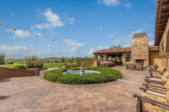 view of patio featuring an outdoor stone fireplace