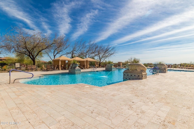 view of swimming pool with pool water feature and a patio area