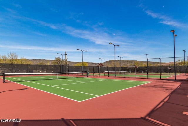 view of tennis court featuring basketball hoop