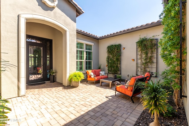 doorway to property featuring outdoor lounge area and a patio area