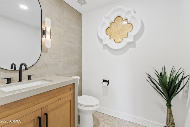 7409 E Pleasant Run, Scottsdale, AZ 85258 - half bath featuring tile walls, vanity, toilet, tile patterned flooring, and baseboards