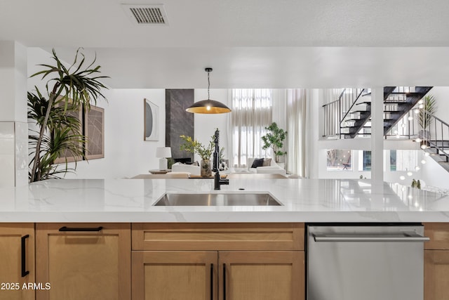 7409 E Pleasant Run, Scottsdale, AZ 85258 - kitchen with stainless steel dishwasher, a sink, light stone counters, open floor plan, and decorative light fixtures