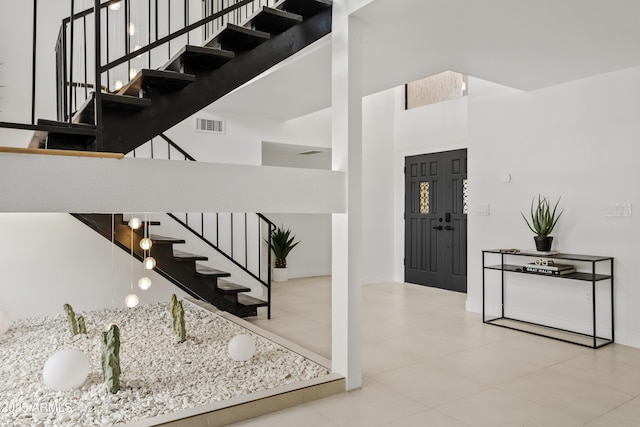 7409 E Pleasant Run, Scottsdale, AZ 85258 - foyer entrance featuring stairs, a towering ceiling, tile patterned flooring, and baseboards