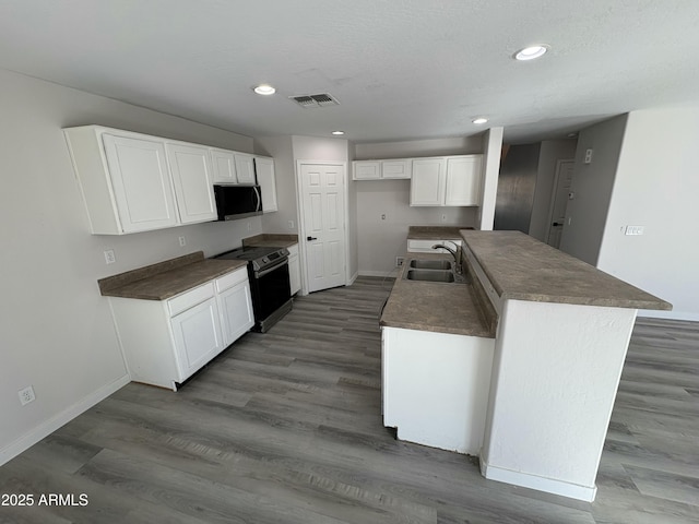 kitchen featuring white cabinets, sink, electric range, a kitchen island, and dark hardwood / wood-style flooring