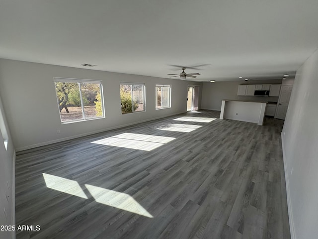 unfurnished living room featuring hardwood / wood-style floors and ceiling fan