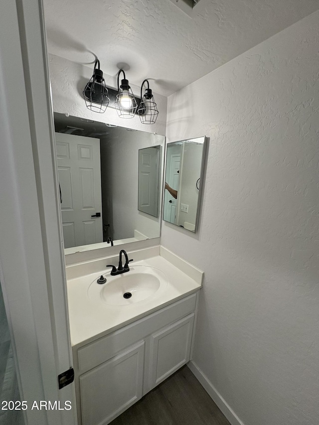 bathroom with vanity, wood-type flooring, and a textured ceiling