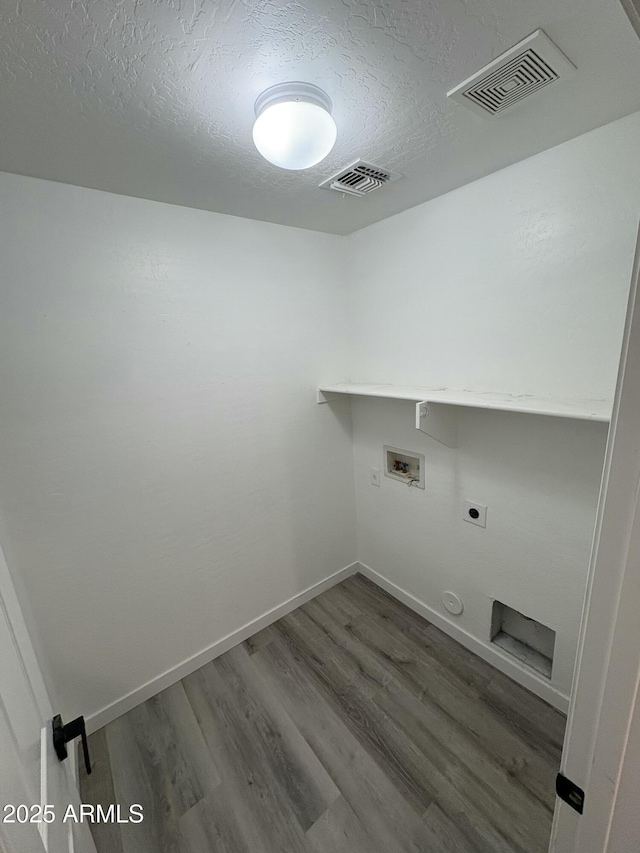 laundry area with hookup for an electric dryer, dark hardwood / wood-style floors, a textured ceiling, and hookup for a washing machine