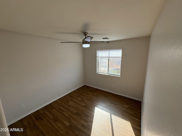 empty room with dark hardwood / wood-style floors and ceiling fan