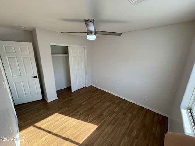 unfurnished bedroom with ceiling fan, dark hardwood / wood-style flooring, and a closet