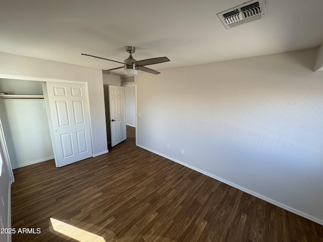 unfurnished bedroom with ceiling fan, dark hardwood / wood-style flooring, and a closet