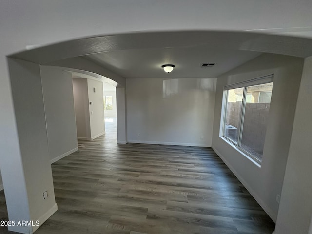 unfurnished room with dark wood-type flooring