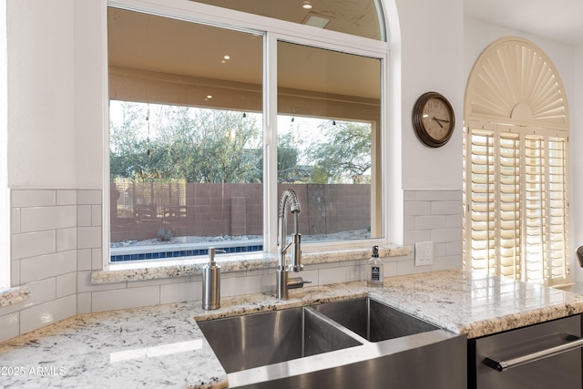 kitchen with light stone counters and sink