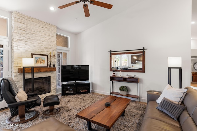 living room featuring lofted ceiling, a fireplace, and ceiling fan