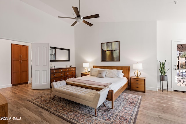 bedroom with ceiling fan, high vaulted ceiling, and light hardwood / wood-style floors