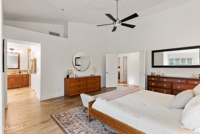 bedroom with high vaulted ceiling, light hardwood / wood-style floors, ceiling fan, and ensuite bathroom