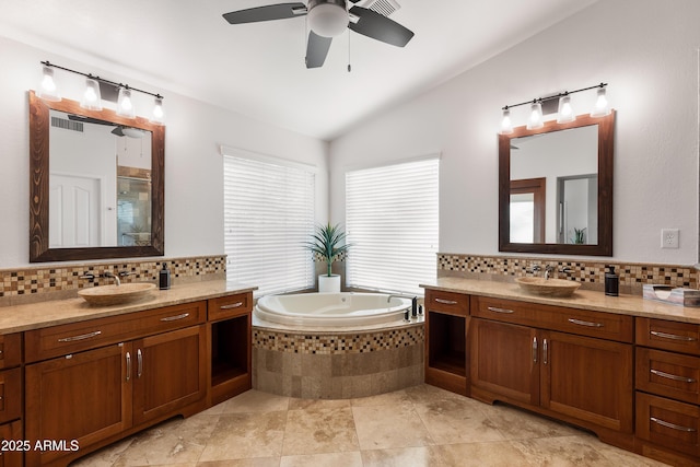 bathroom featuring lofted ceiling, vanity, decorative backsplash, and independent shower and bath