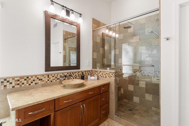 bathroom with vanity, a shower with door, and backsplash