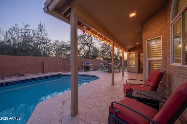 pool at dusk with a patio area