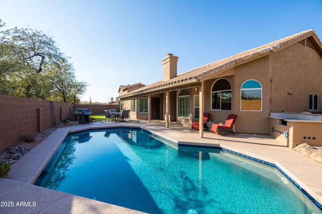 view of swimming pool featuring area for grilling and a patio