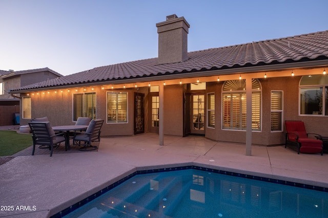 pool at dusk with a patio