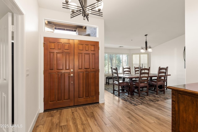 foyer entrance with a notable chandelier and light wood-type flooring