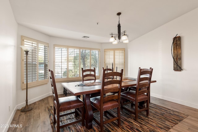 dining space featuring dark hardwood / wood-style floors and a notable chandelier