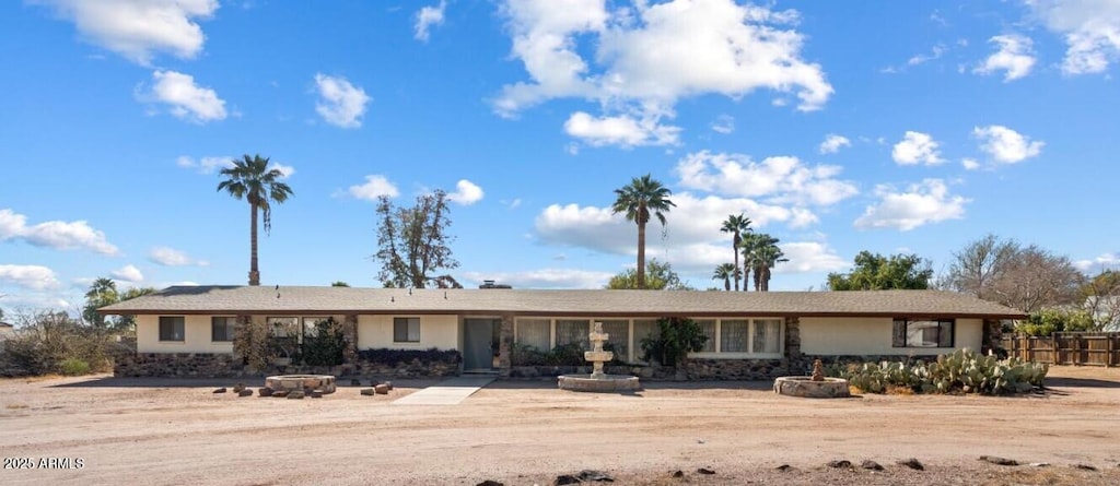 ranch-style home featuring a fire pit