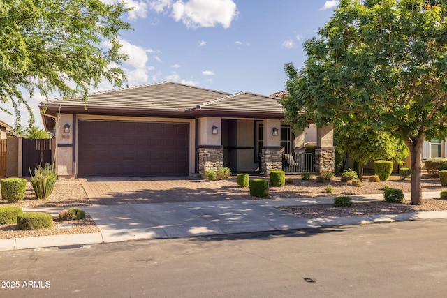 view of front of property with a garage, driveway, stone siding, and stucco siding