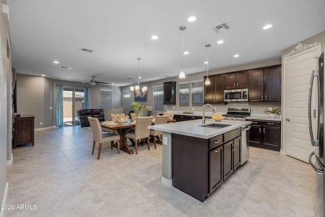 kitchen with a sink, dark brown cabinetry, light countertops, appliances with stainless steel finishes, and visible vents