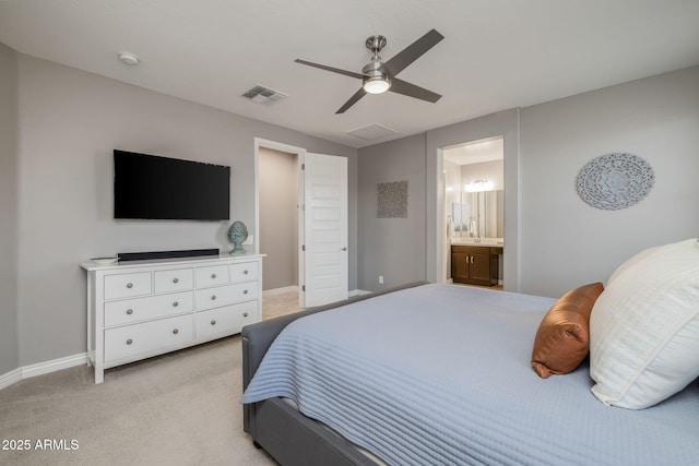 bedroom with ensuite bathroom, baseboards, visible vents, light colored carpet, and a ceiling fan