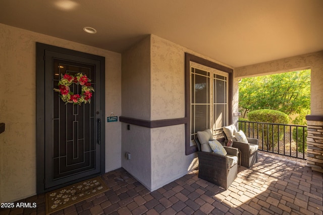 doorway to property with a porch and stucco siding