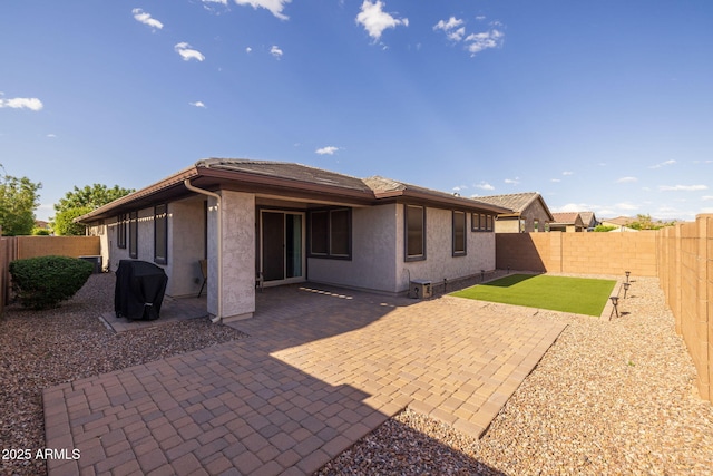 back of property with stucco siding, a patio area, and a fenced backyard