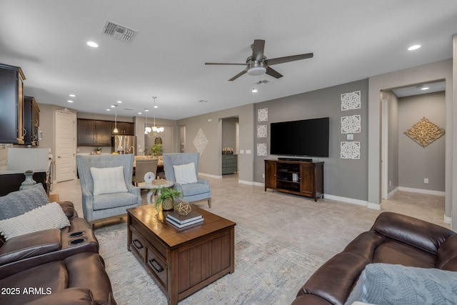 living room with recessed lighting, visible vents, baseboards, and ceiling fan with notable chandelier