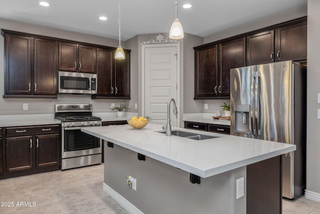 kitchen with light countertops, dark brown cabinets, appliances with stainless steel finishes, and a sink