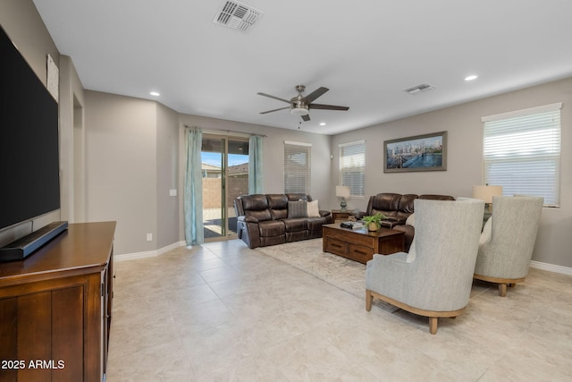 living area featuring a ceiling fan, visible vents, and a healthy amount of sunlight
