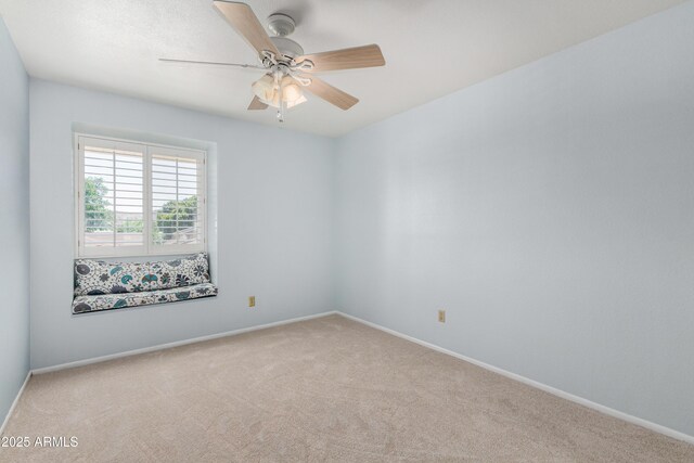 spare room with carpet, ceiling fan, and baseboards