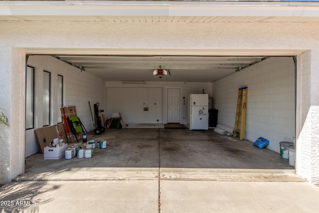 garage with freestanding refrigerator and a garage door opener