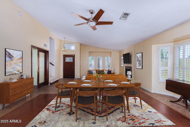 dining area featuring lofted ceiling, visible vents, baseboards, wood finished floors, and a ceiling fan
