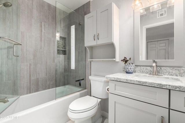 full bath with toilet, visible vents, vanity, and enclosed tub / shower combo