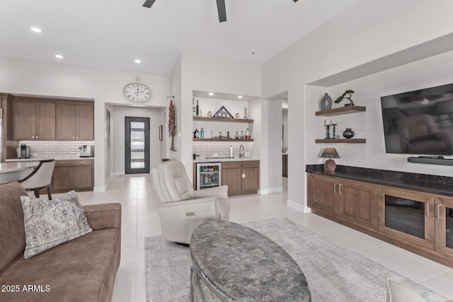 tiled living room featuring indoor bar, wine cooler, and ceiling fan