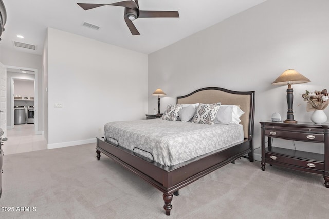 carpeted bedroom with washer and dryer and ceiling fan