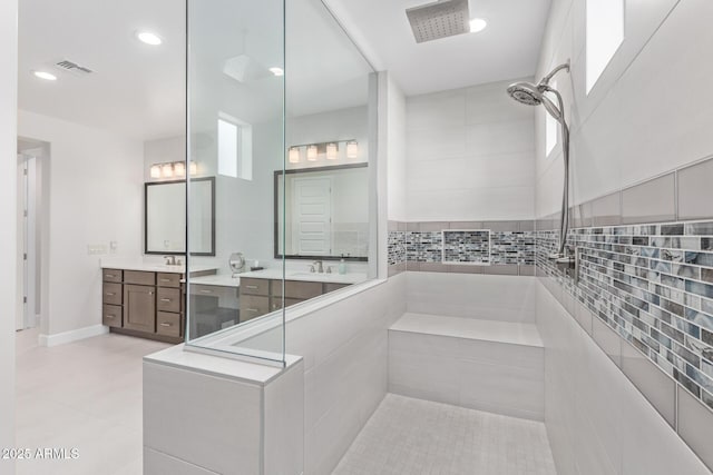 bathroom with tile patterned flooring, vanity, and walk in shower