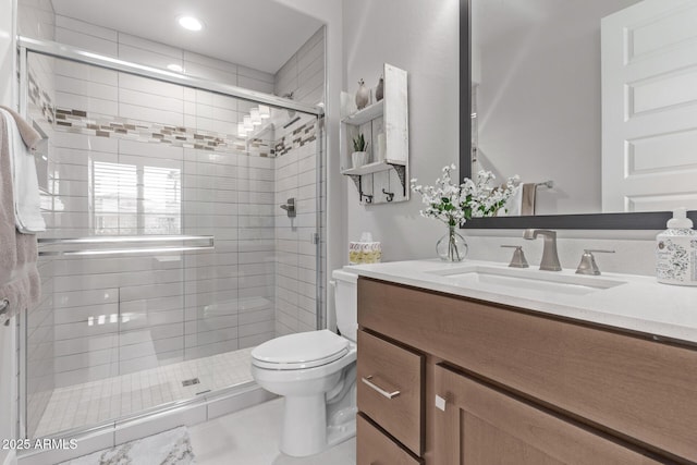 bathroom with tile patterned flooring, a shower with door, vanity, and toilet