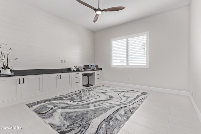 interior space featuring ceiling fan and built in desk