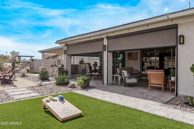 rear view of property with a patio area, an outdoor living space, and an outdoor kitchen