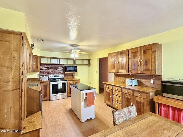 9495 E Marilyn Ln, Dewey, AZ 86327 - kitchen with electric range, black microwave, backsplash, light wood-style floors, and a kitchen island