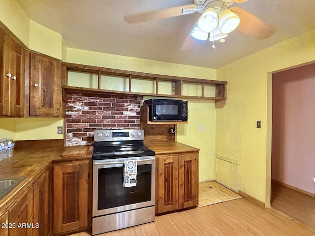 9495 E Marilyn Ln, Dewey, AZ 86327 - kitchen featuring stainless steel range with electric stovetop, black microwave, ceiling fan, light wood-type flooring, and glass insert cabinets