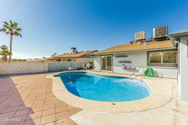 view of swimming pool with cooling unit and a patio area