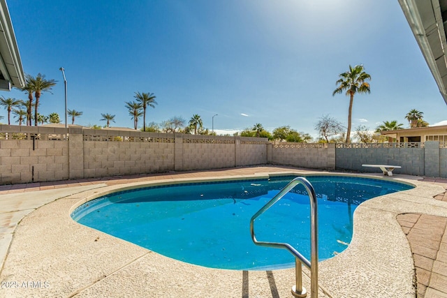 view of swimming pool featuring a diving board